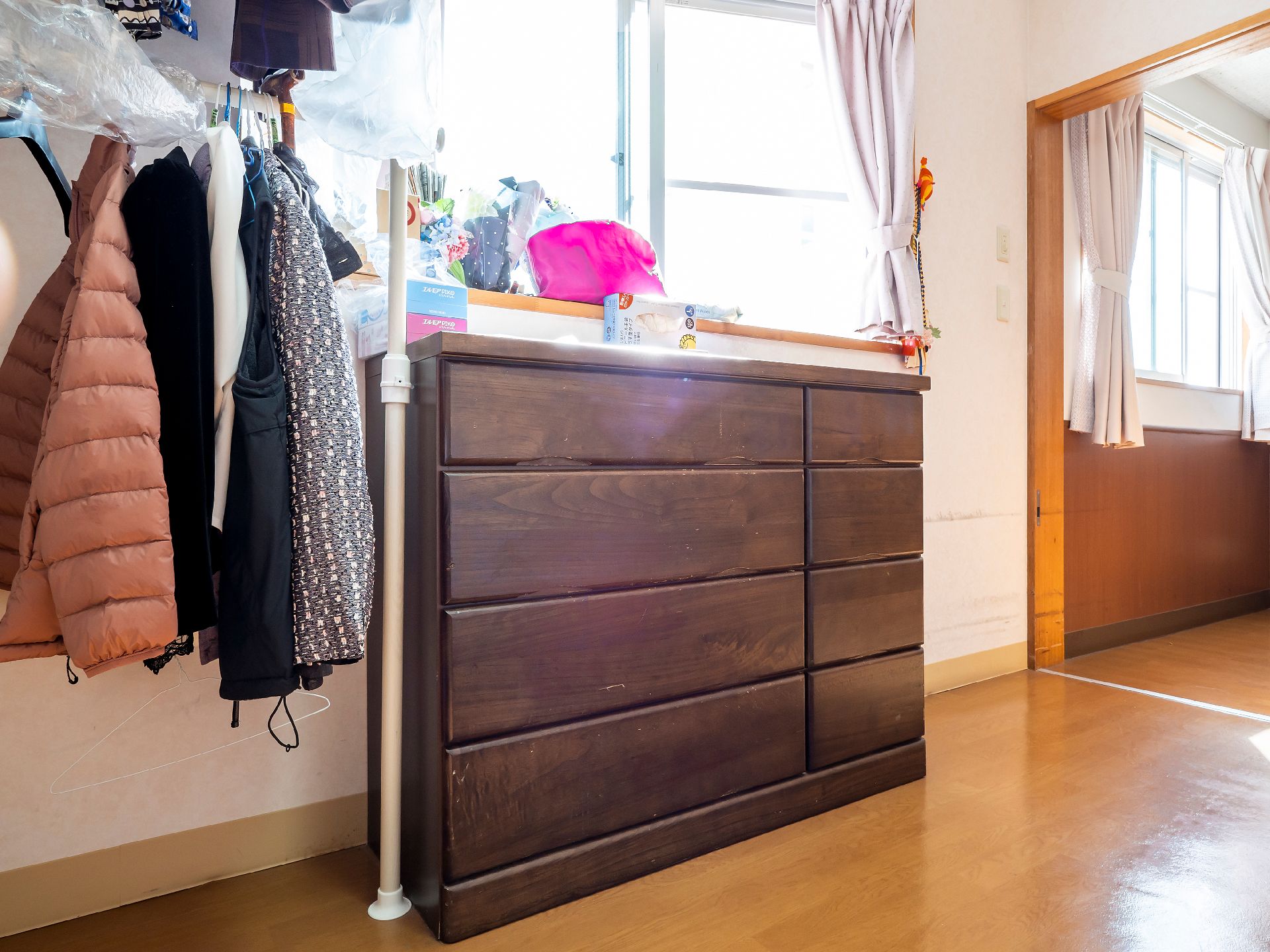 手を振る高齢女性と後ろで見守る女性ヘルパー