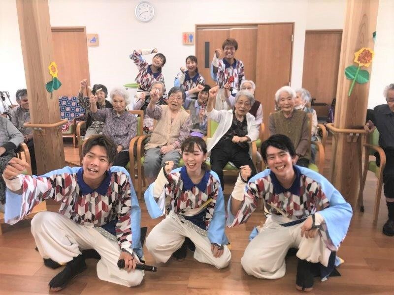 イベントでボランティアの方々と入居者があつまった笑顔の集合写真