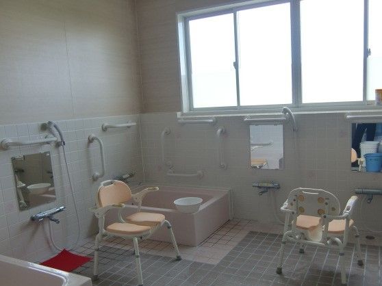 個浴が複数置かれた広い浴室。シャワーチェアや手すりなどもある。