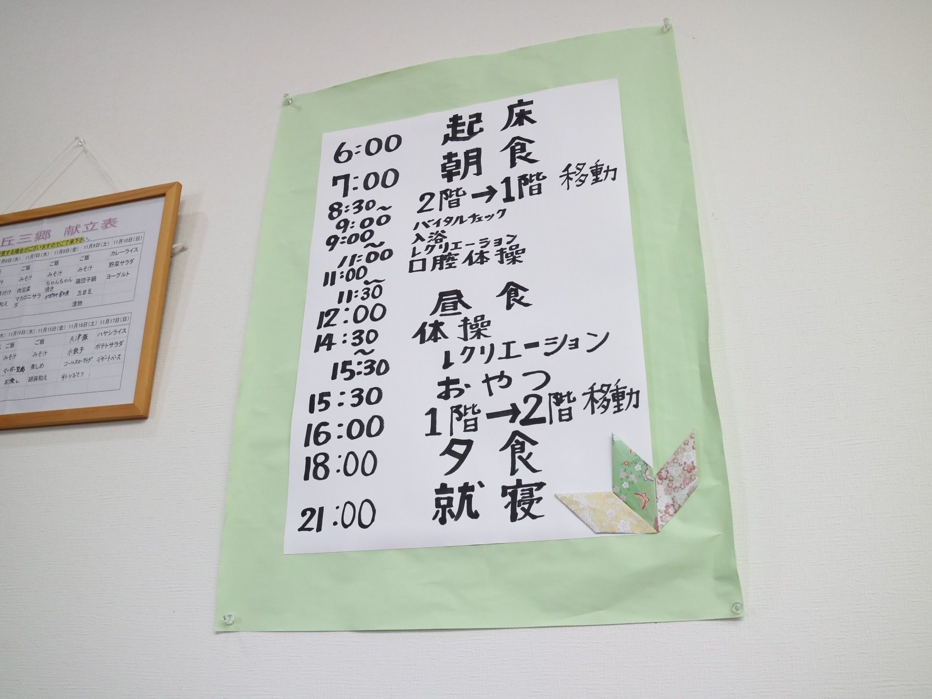 壁に献立表や一日の行動予定表が貼られている。規則正しい生活が送れるよう、目につく場所に設置している。