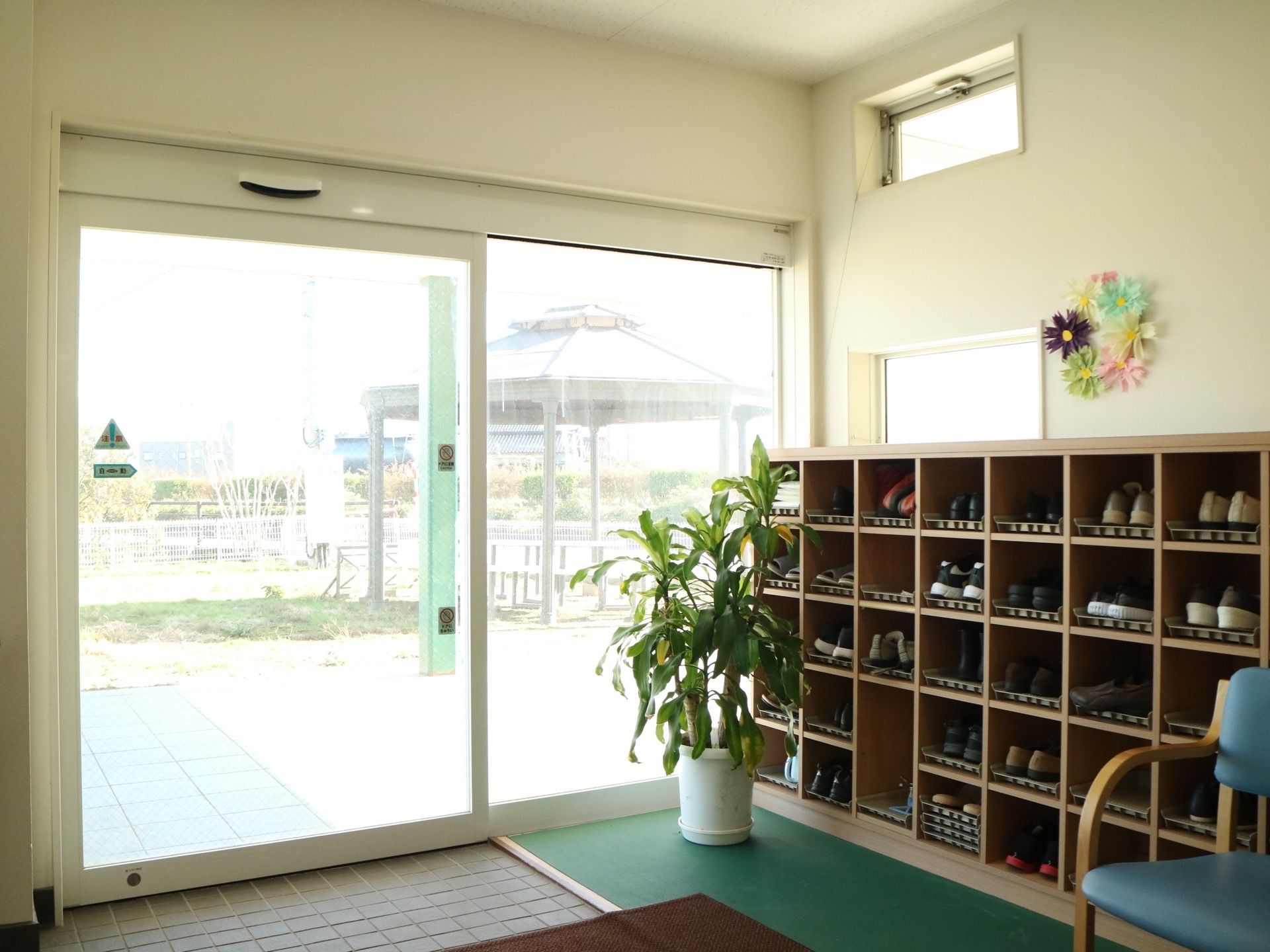 自動ドアが設置されている。玄関から外の風景が見渡せる。扉を設けない、オープンタイプの靴箱が備え付けられている。