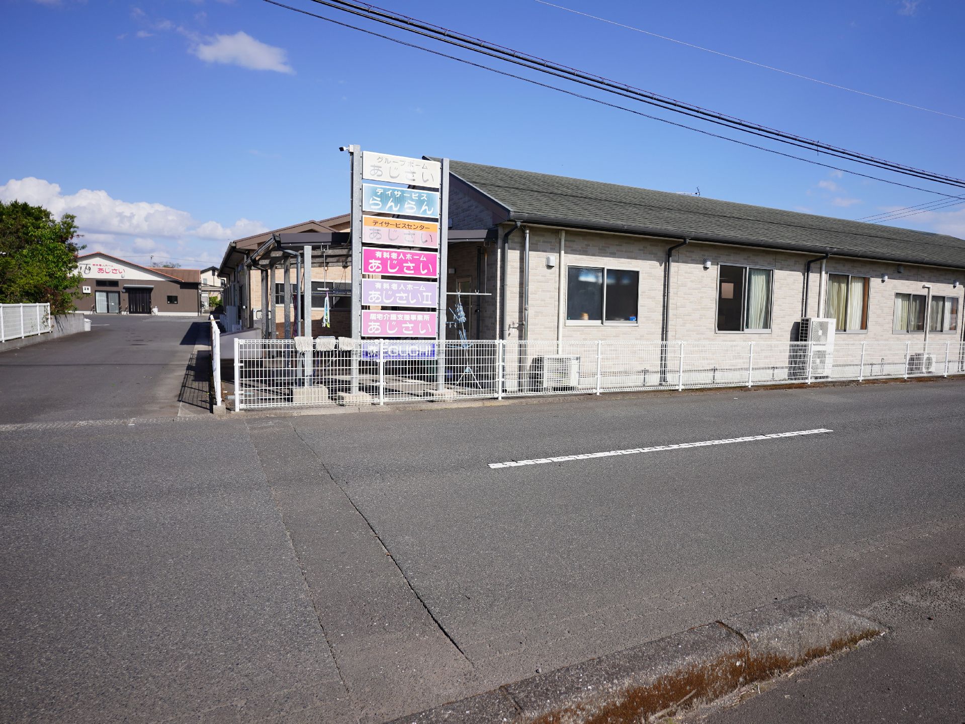 駐車場の出入り口から見た、斜め前から見た施設全体の外観