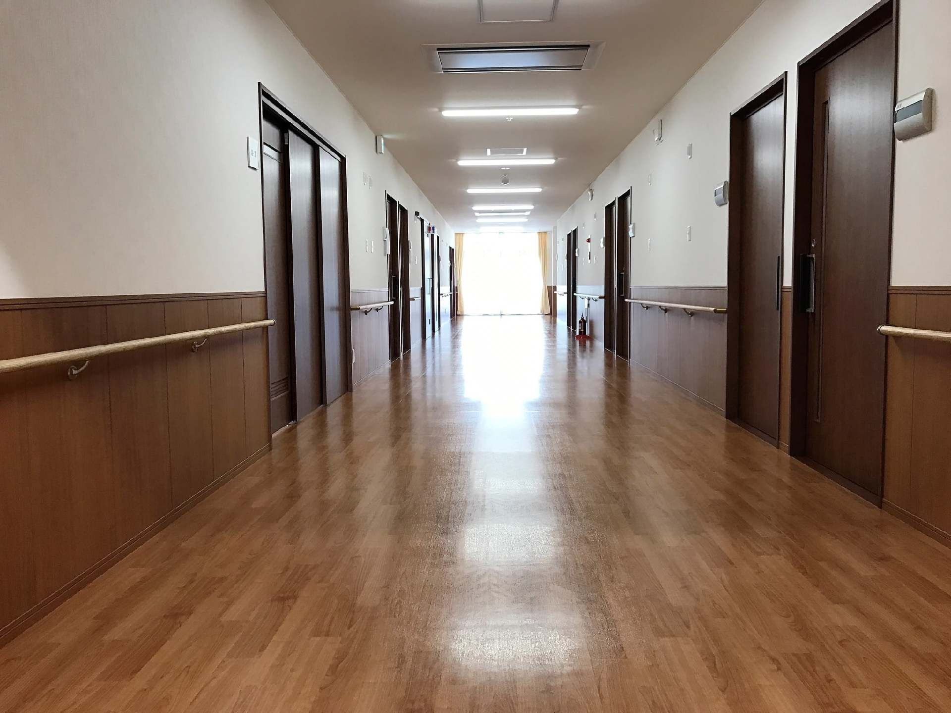 廊下はまっすぐで両サイドに手すりが付いている。居室は引き戸で開け閉めが楽にできるデザイン。