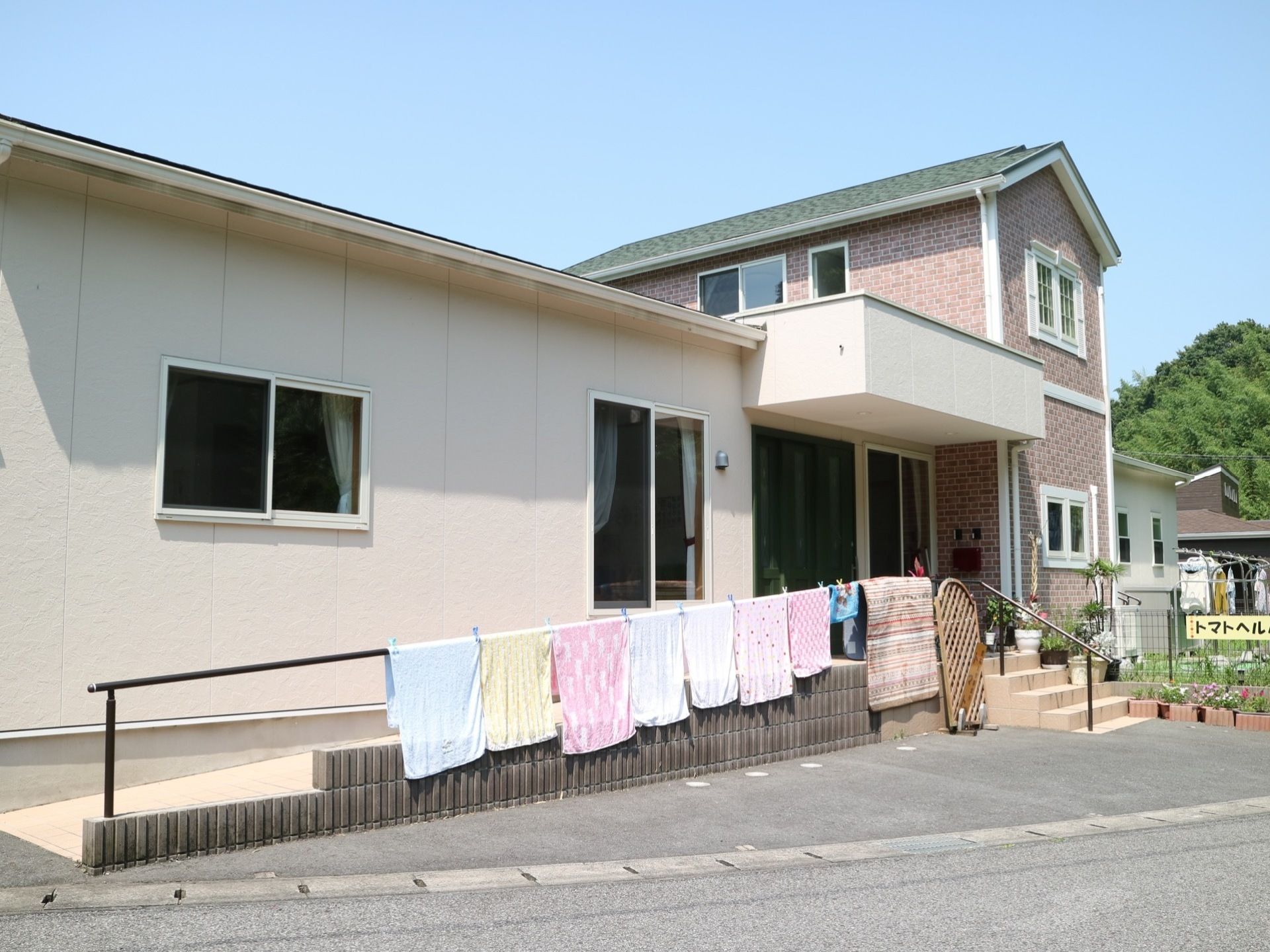 施設は中央に２階建ての建物があり、両側に１階部分がつながっている構造である。玄関までは階段とスロープが設置されている。
