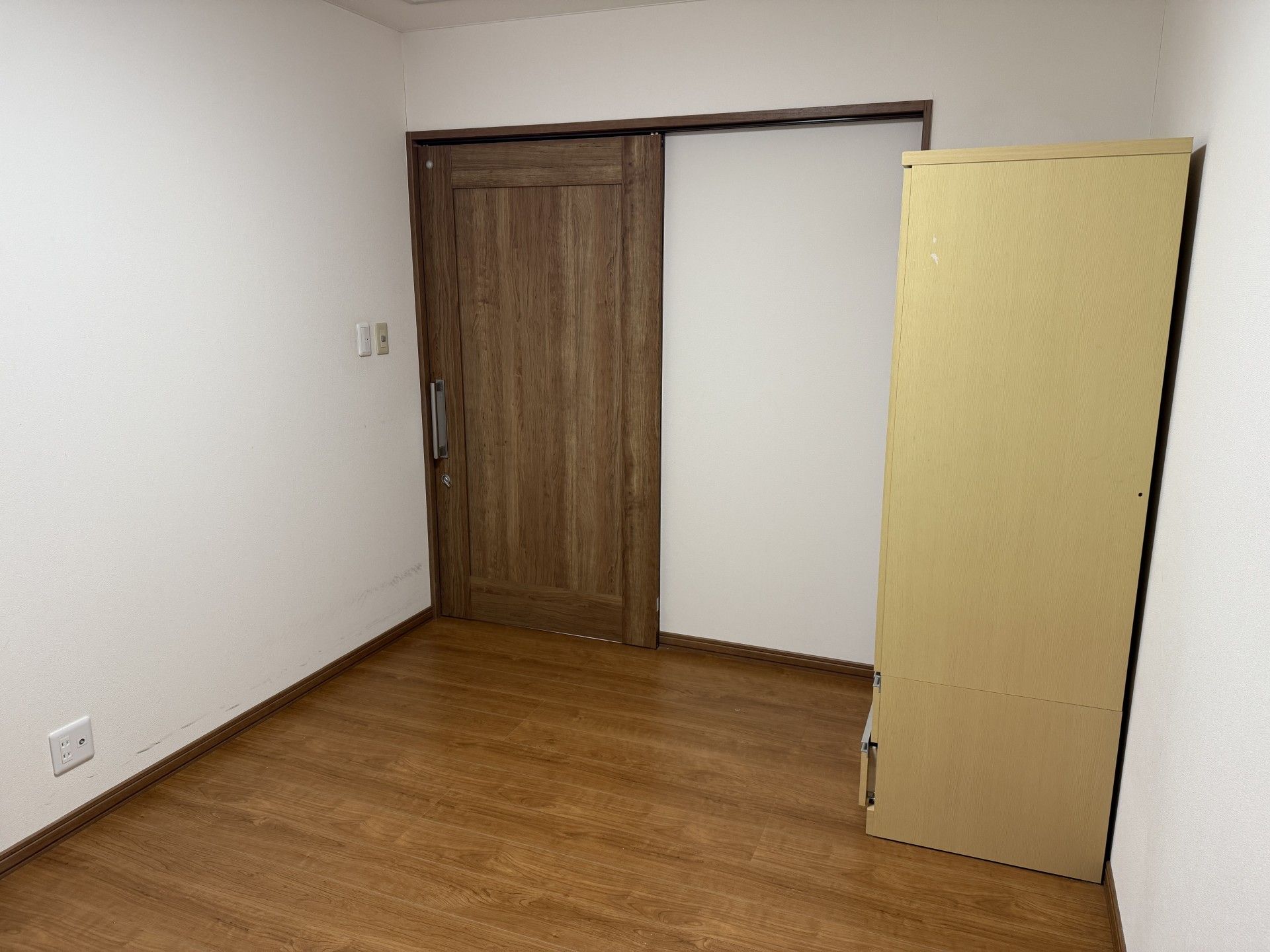 木製ドアと収納棚の部屋