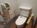 温水便座が設置されたトイレには２つの手すりが付いている。一つは可動式で状況に応じて利用できる。操作パネルも壁についている。