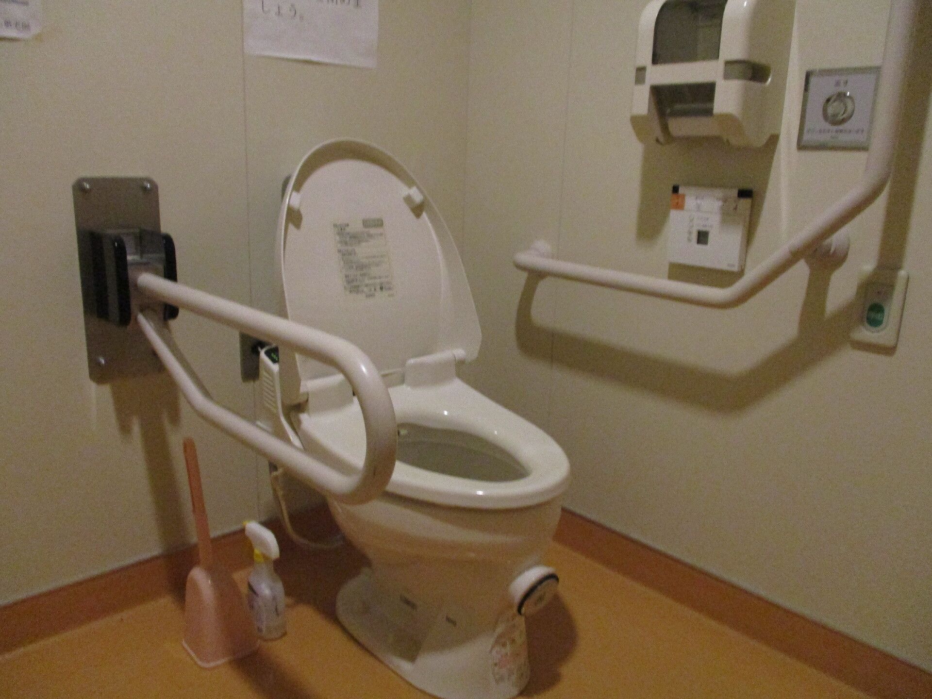シンプルなトイレは両サイドに手すりが付いている。2つある手すりの一つは可動式で状況に応じて利用することが可能。呼び出しボタンもある。