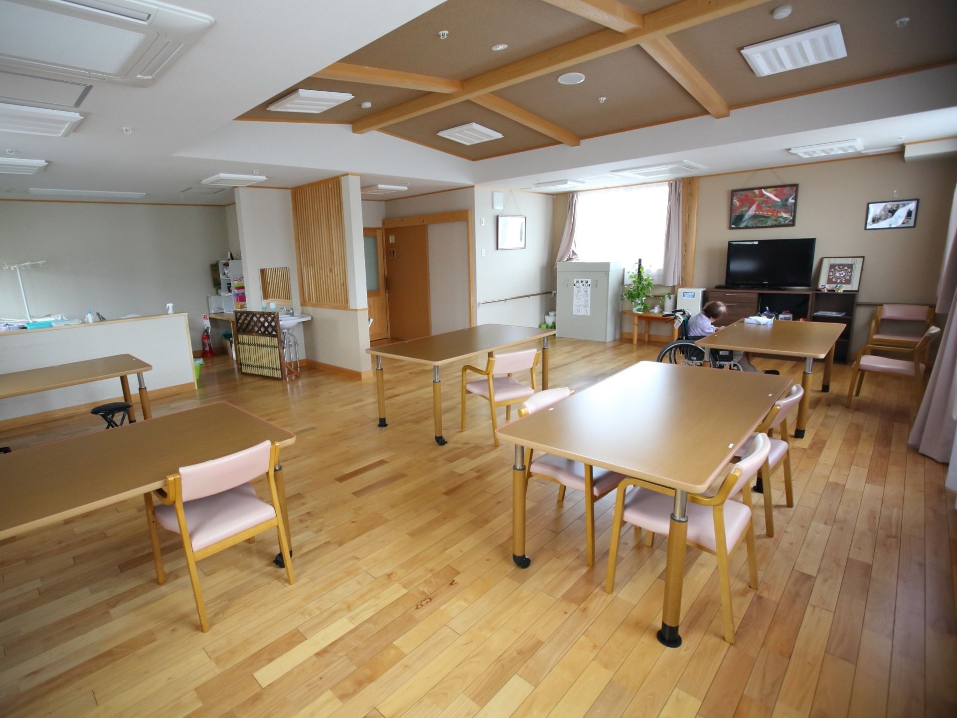 天井が高く広々とした食堂である。キッチンが備わっており、椅子がセットされたダイニングテーブルが用意されている。