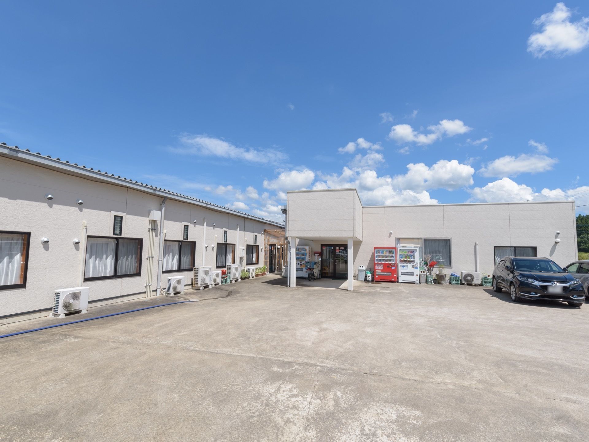 駐車場を完備した1階建ての施設である。各居室にはエアコンが完備されており、窓下には室外機がある。
