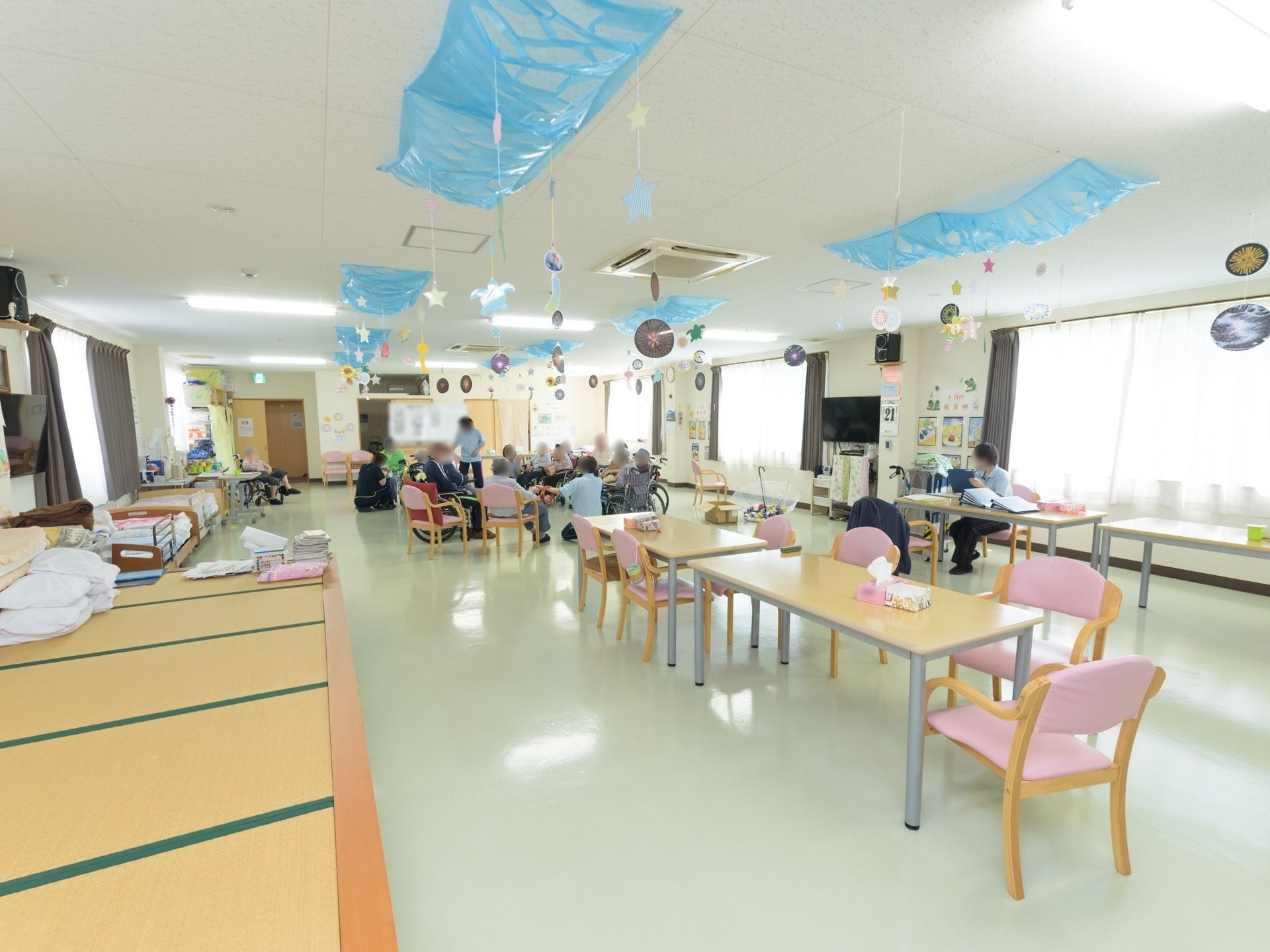 左側に畳を敷いた小上がりがあり、テーブルが並べられた共用スペース