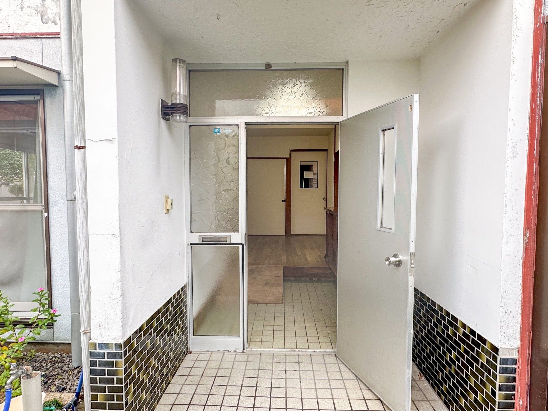 陽ざしの良い場所で何かを見つめている高齢女性と介護スタッフ。やわらかい表情のふたり