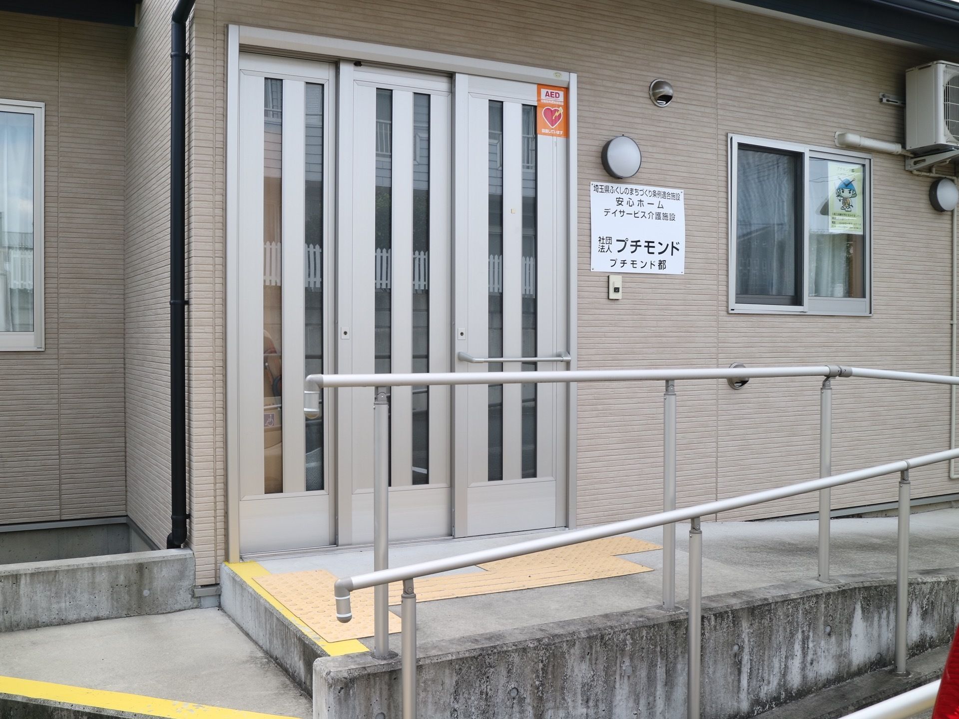玄関前には、数段の階段があり、縁に黄色いテープを貼っている。スロープには、手すりがあり、なだらかな坂で上りやすい。