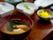 みそ汁が手前にあり、奥には小鉢がたくさん並んでいる。料理はぼやけていて見えない。