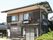 2階建ての建物は木造で、玄関には屋根が付き、玄関先には2脚の椅子が並べられている。瓦の三角屋根が付き一般の住宅のような外観。