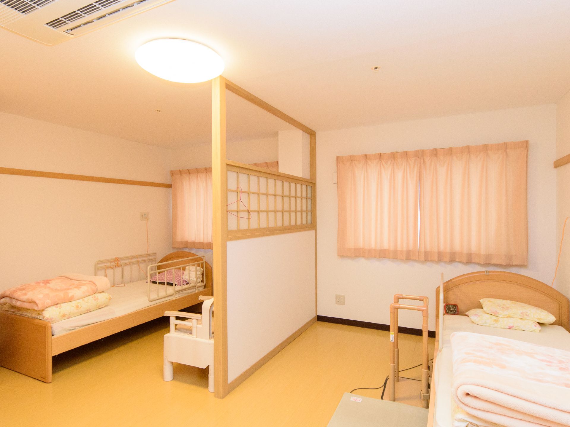 真ん中に障子のはまった仕切りがあり、奥と手前のスペースにそれぞれベッドが置かれた部屋