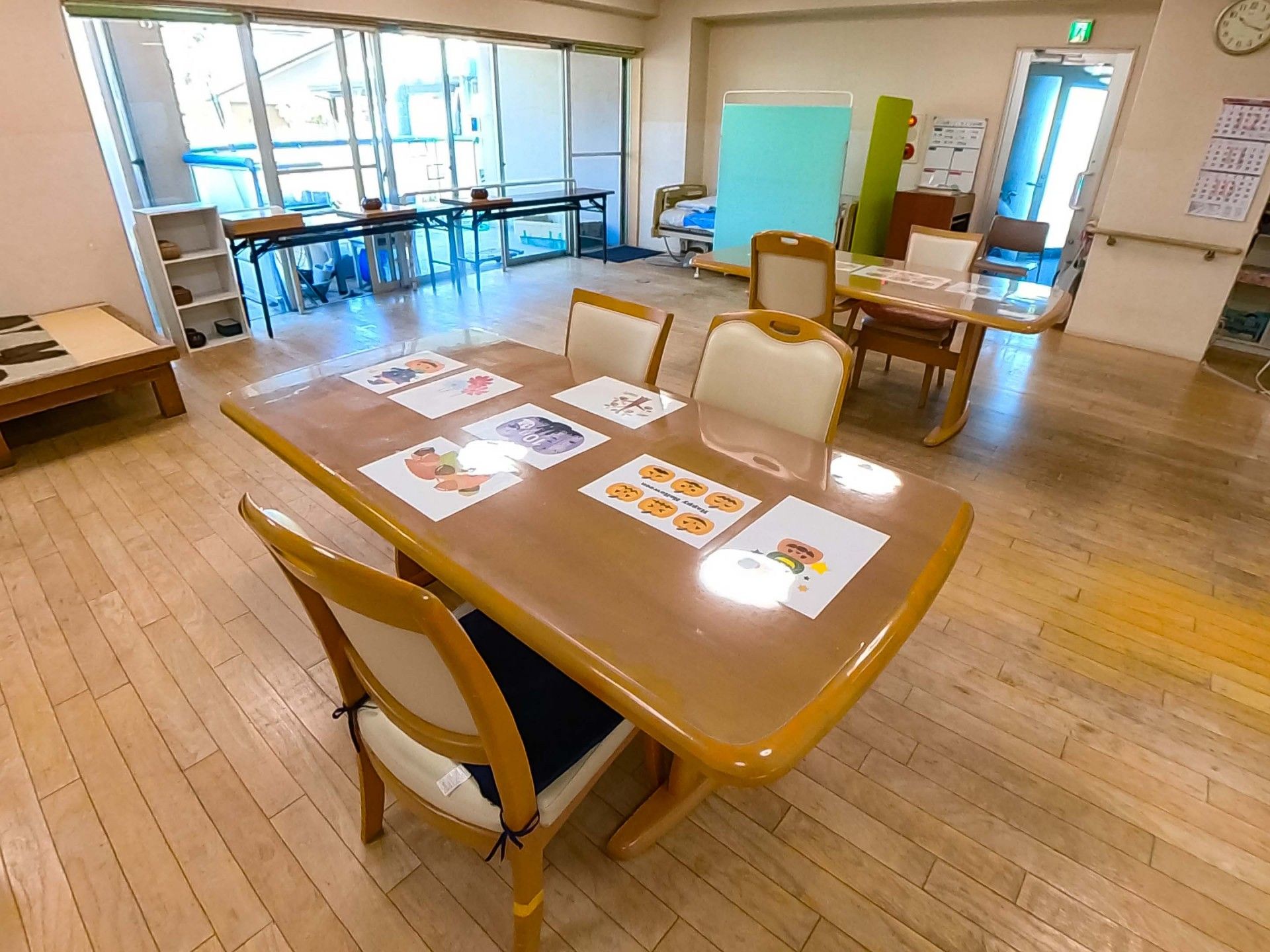 ピンクのエプロンを付けた女性スタッフがカーディガンを着た高齢女性に寄り添い、2人とも笑顔。