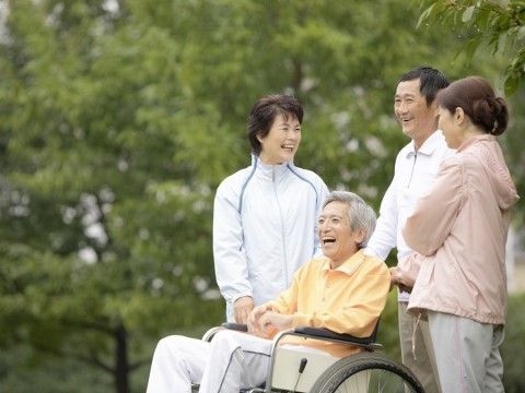 車いすに座っている男性と寄り添う介護スタッフ