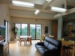 ソファが置いてある施設内のリビングルーム。奥のほうに窓があり景色が広がっている様子