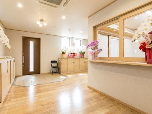 玄関には段差がなく、パイプ椅子が一脚置かれている。スタッフルームはガラス張りで明るい。