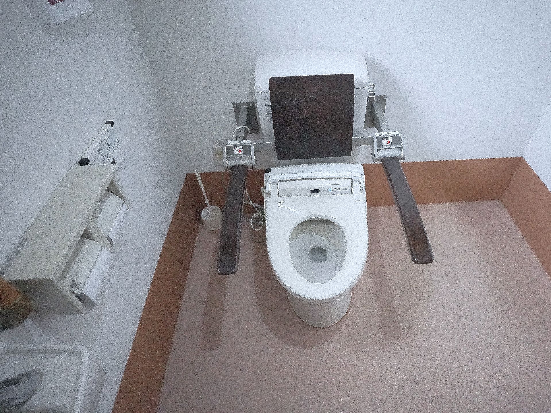 高齢女性たちの輪の中に入って楽しそうにしゃべっている白衣を着た女性スタッフ。
