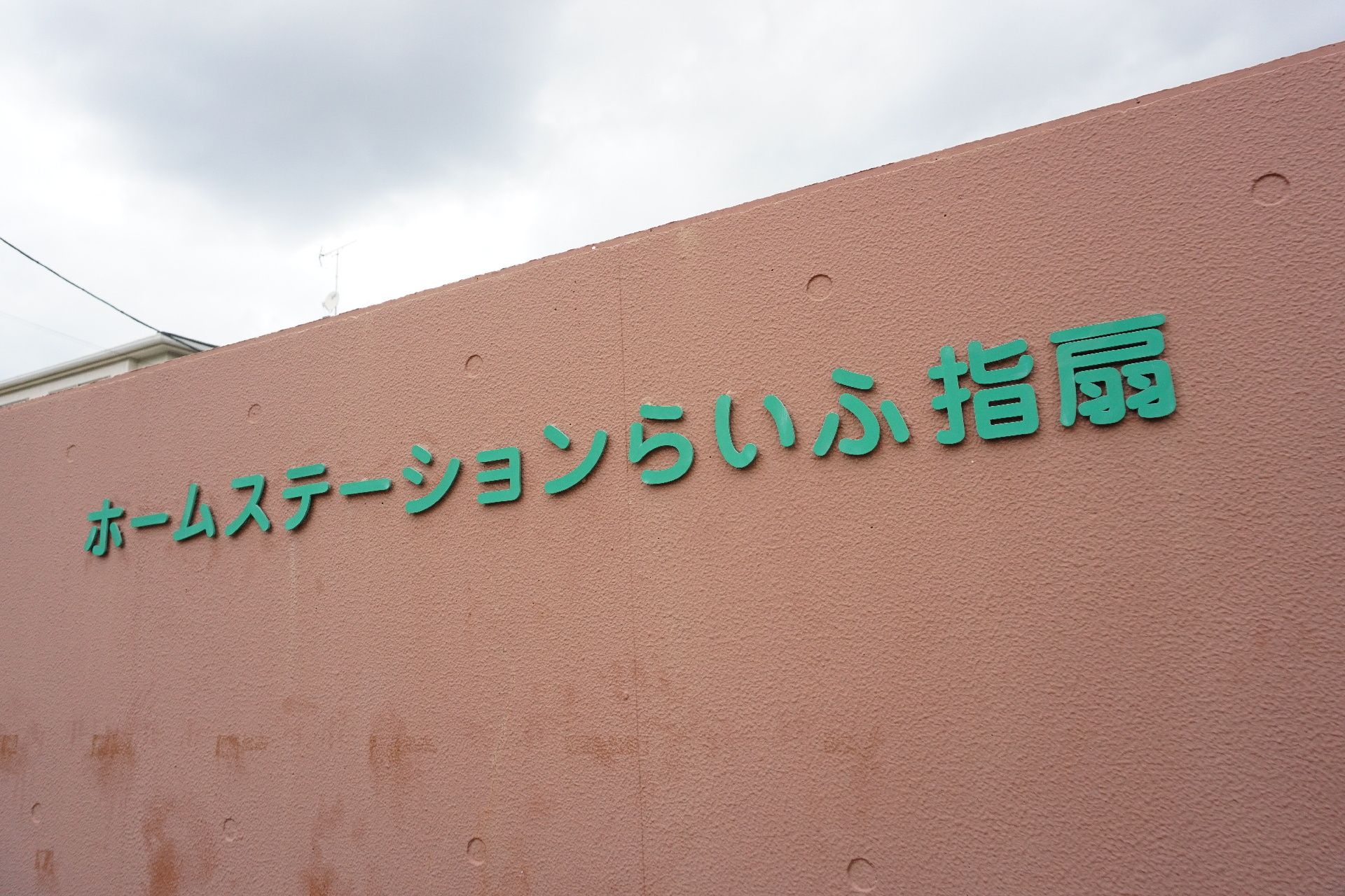 外壁に取り付けられ、緑の文字プレートで表記された施設の名称