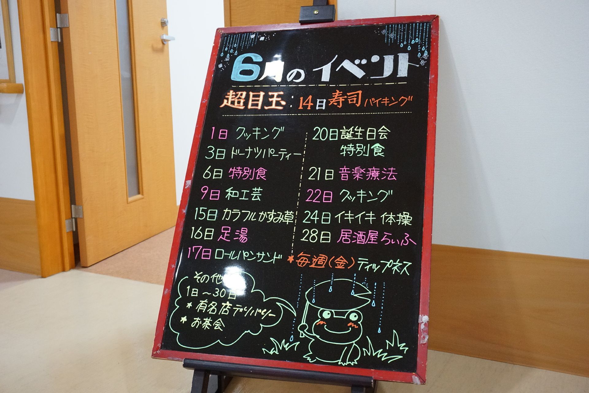 館内の共有スペースに設置されているイベントの予定が書かれた黒板の立て看板