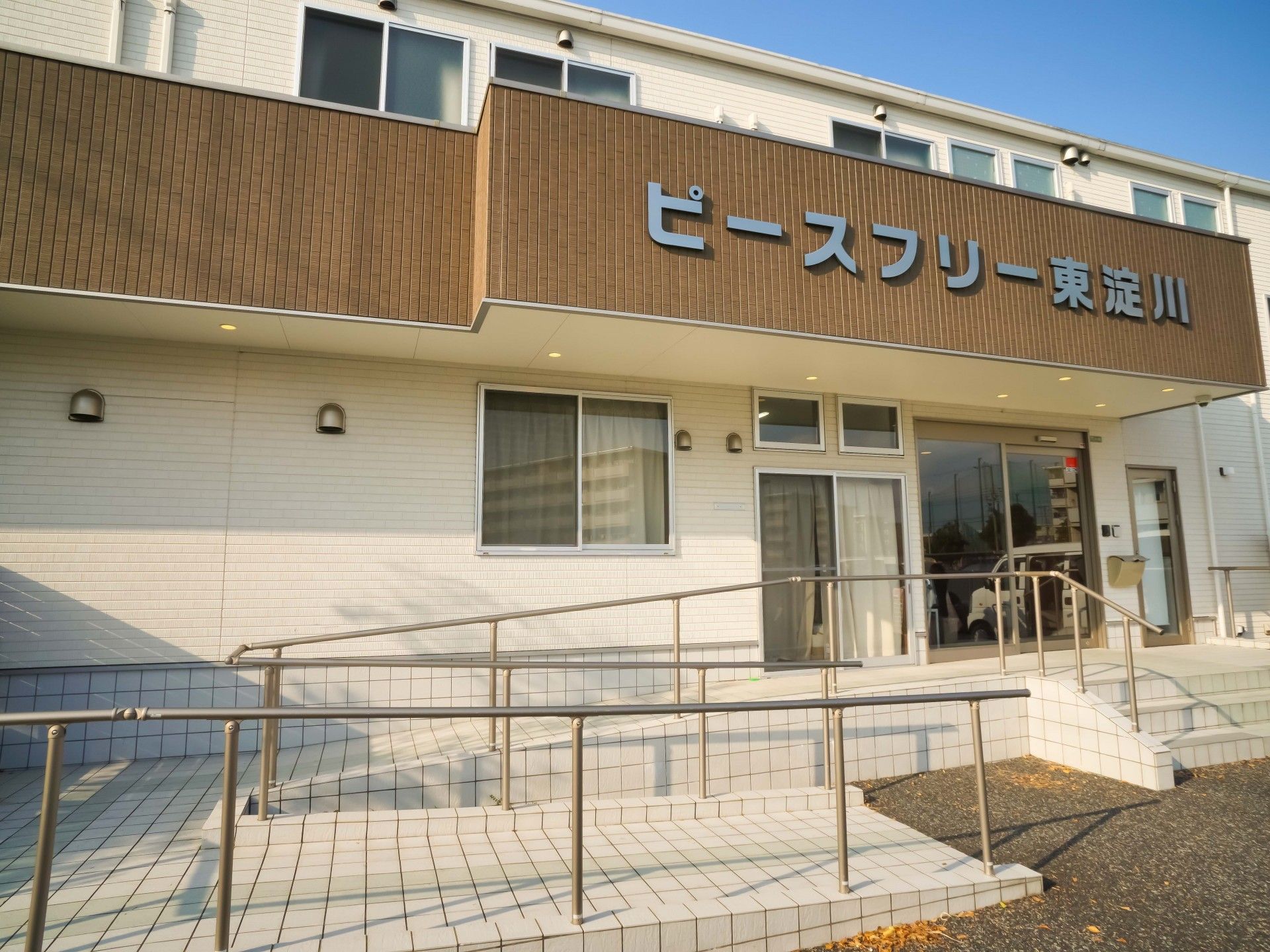 なにかを指さして笑顔で話している車いすの女性とそれを押している介護スタッフの様子