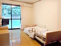 大きな窓が付いた居室は日当たりがよく明るい。ベッドやエアコン、テレビなどが設置されている。