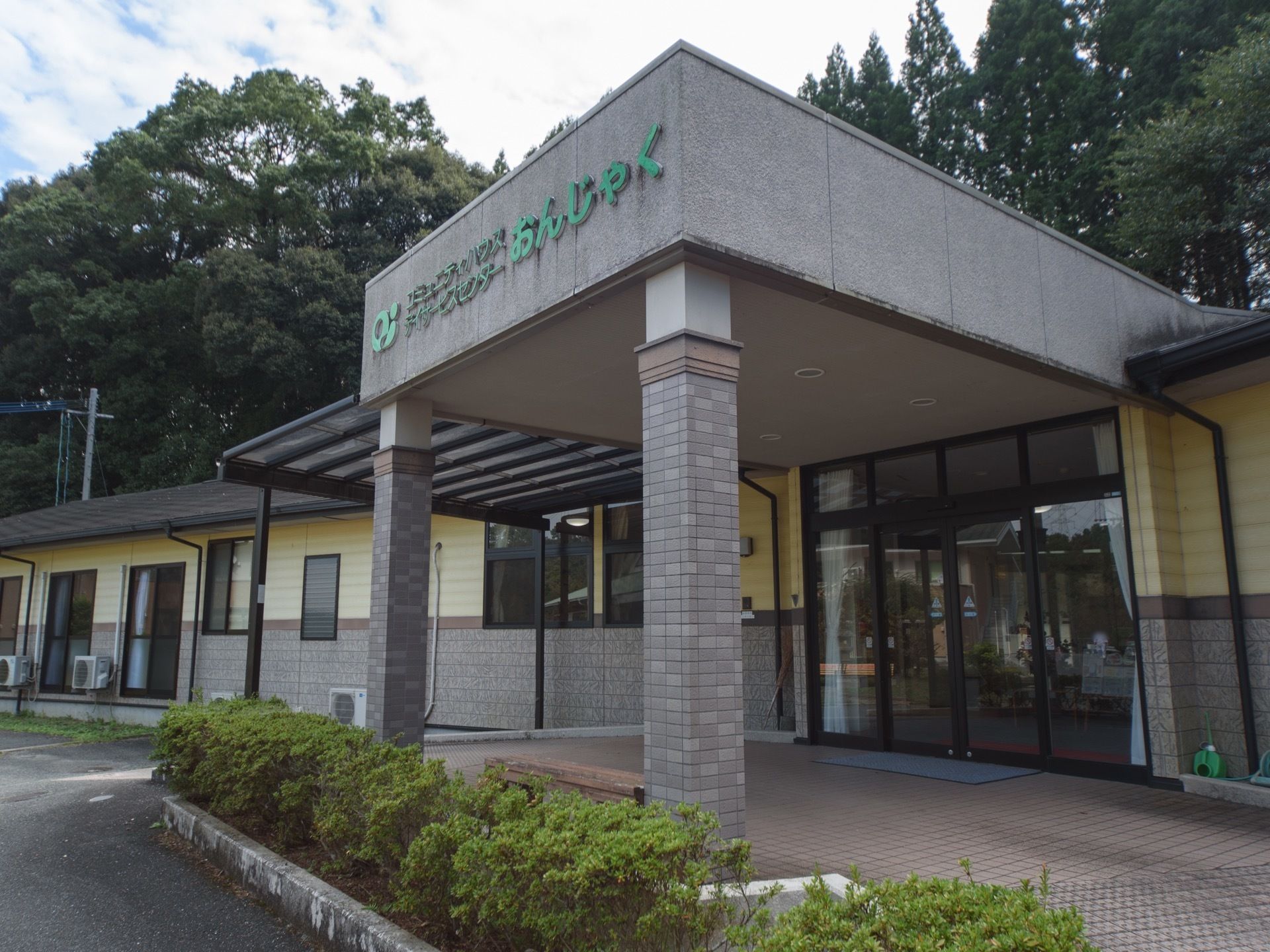 入口は４枚のガラス窓からなり、カーテンがかかっている。屋根の２本の柱には、グレーのタイルと飾りが付いている。