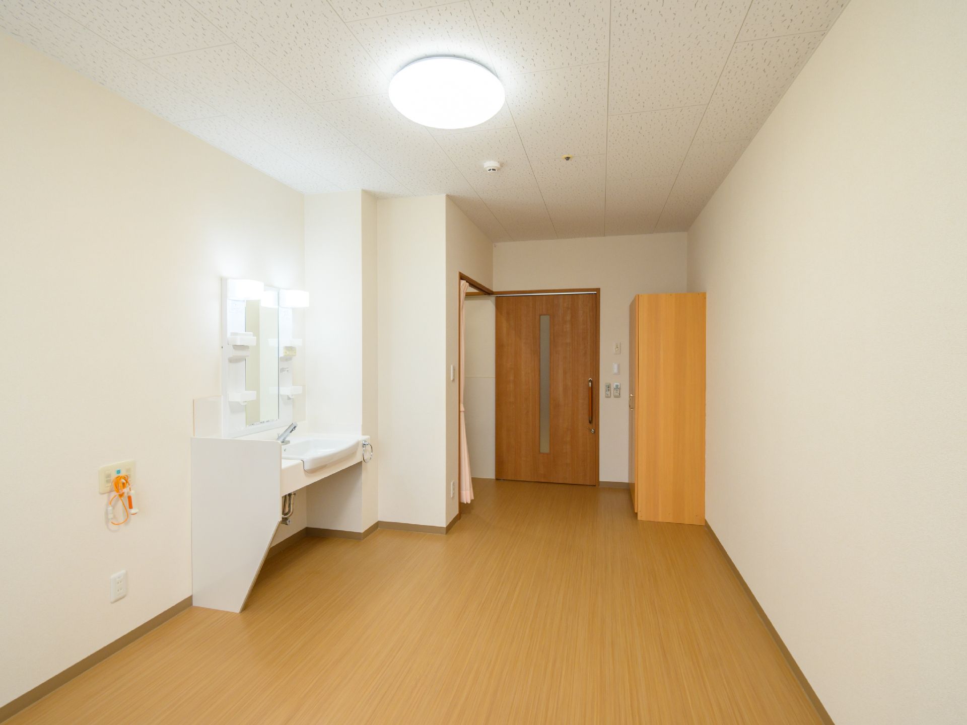 日差しが差し込み、介護ベッドや家具に日差しが当たっている居室