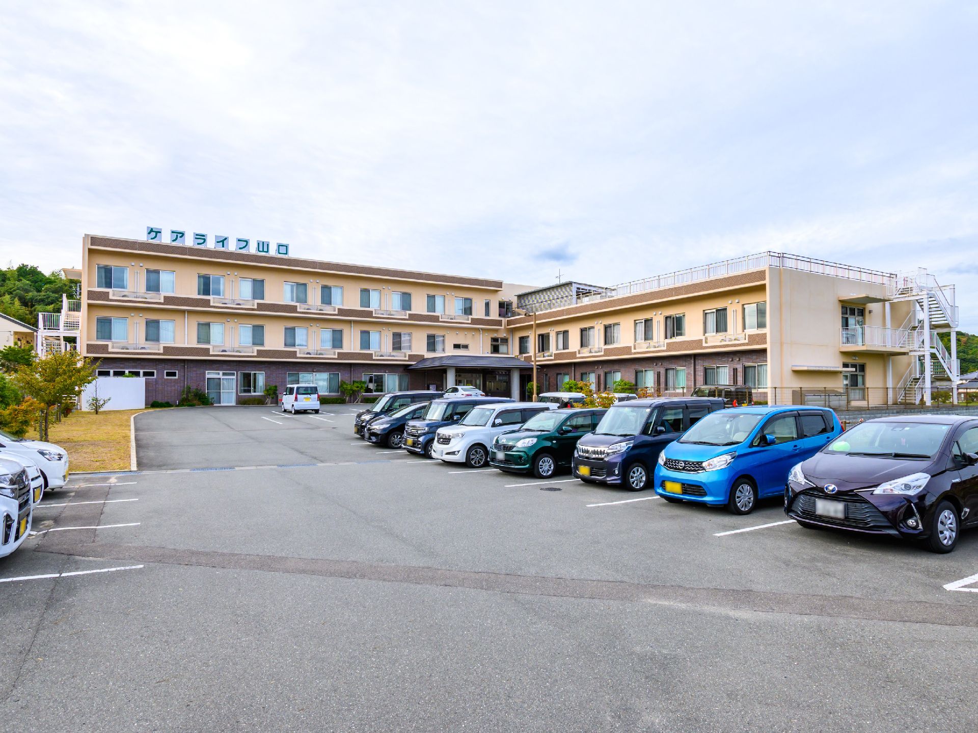 落ち着いた色合いで、駐車場も設置されている外観