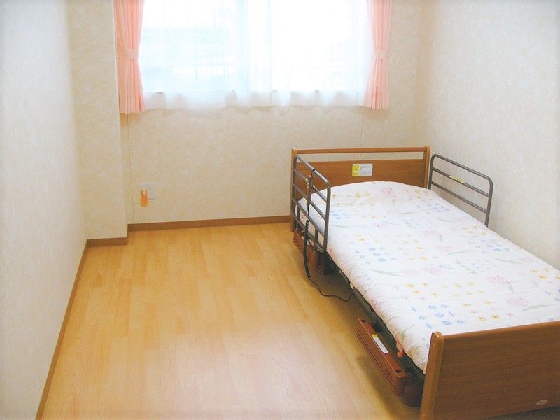 居室はシンプルにベッドが設置されている。窓が大きく日当たり良好。