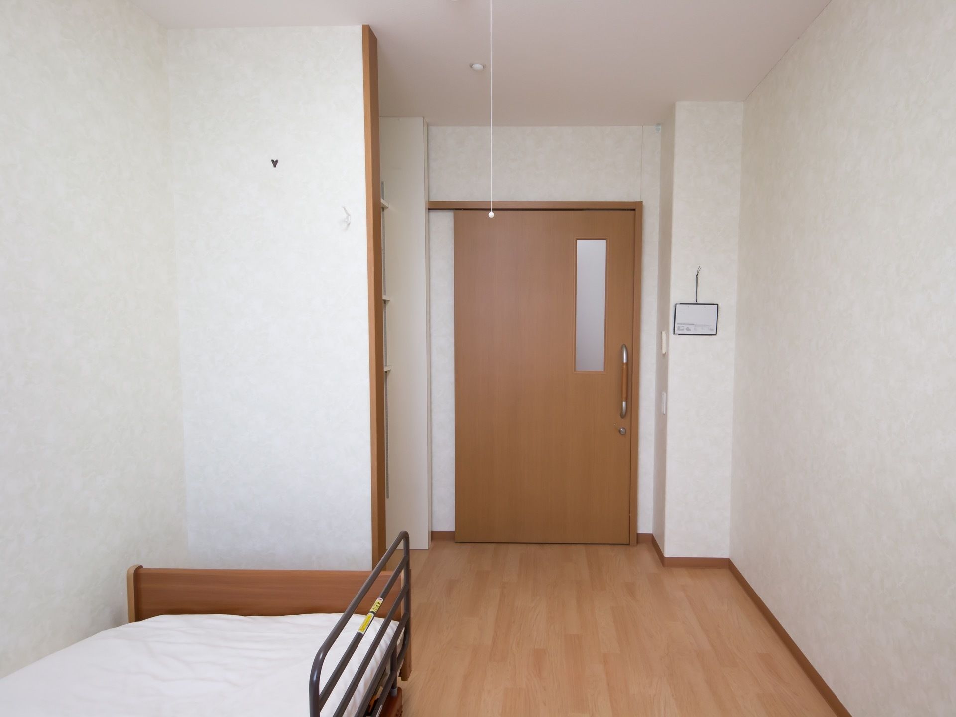 柵のついたベッドが、壁際に置かれている。ドアからベッドまで仕切りや障害物がなく、真っすぐ進むことができる。