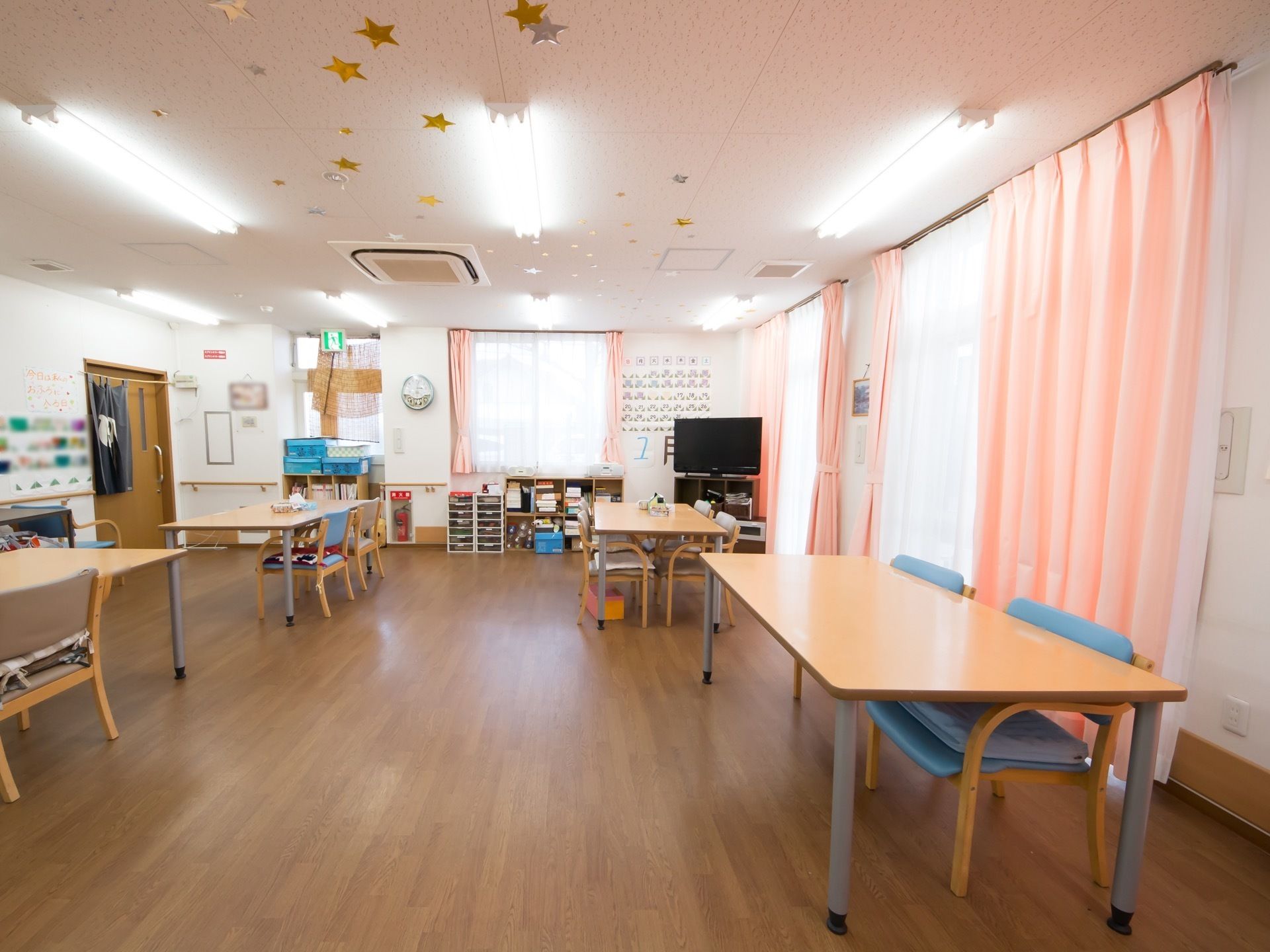 壁は真っ白で展示物が貼ってあり、隣のドアには暖簾がついている。テーブルの上には、ティッシュやくず入れが用意している。
