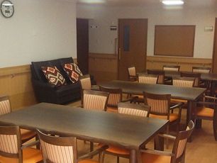 ソファやダイニングテーブルが複数置かれた食堂。ストライプ柄の椅子が木製のテーブルにセットされている。