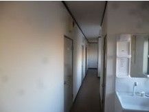 廊下には洗面台が付き、余計なものは置かれていない。居室のドアが見える。