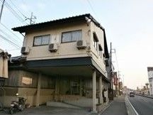 ２階建ての建物の１階部分には広い駐車場が広がっている。和風の建物。