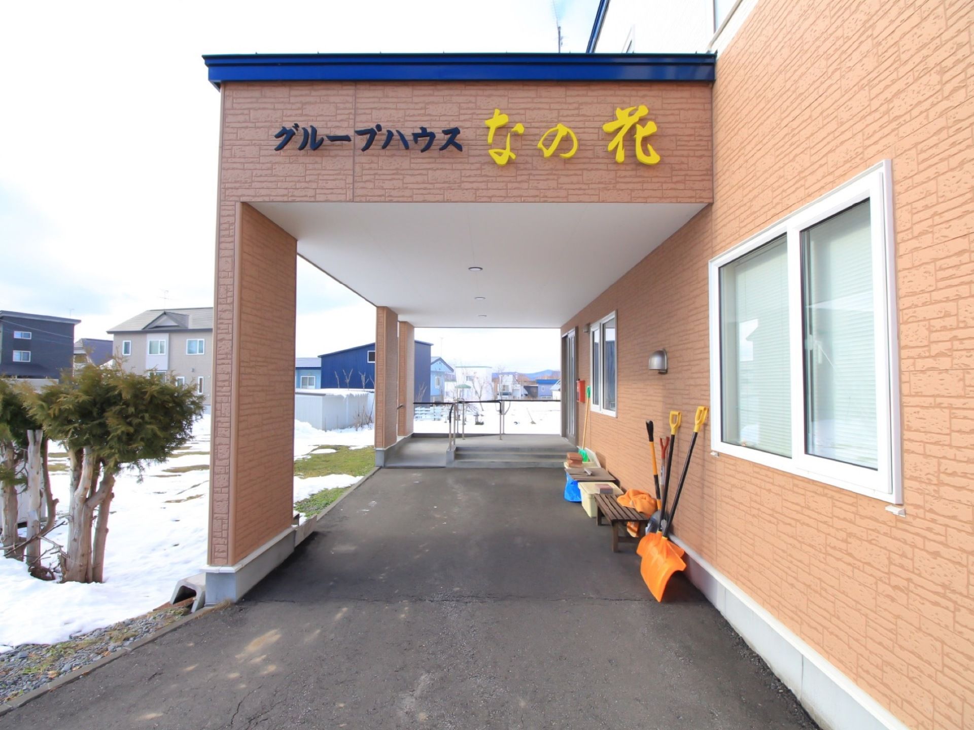 エントランスまでの通路には屋根が設置され、車寄せとなっている。入口まで車で移動できるので、外出時にも入居者様の負担が少ない。