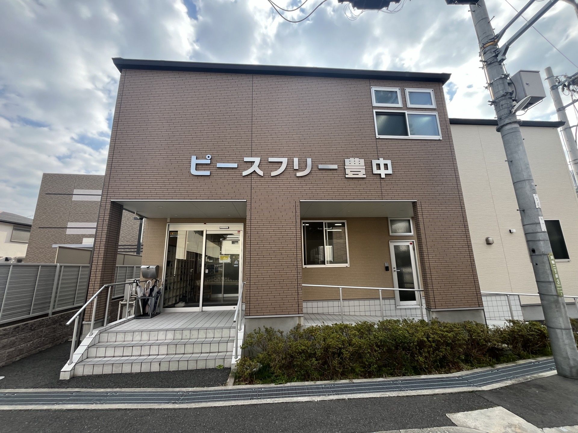 なにかを指さして笑顔で話している車いすの女性とそれを押している介護スタッフの様子