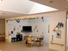手作りの飾りがたくさん飾られた共有スペースには大きなテレビがあり、テーブルセットも置かれ、大きなボーリングのピンも置かれている。