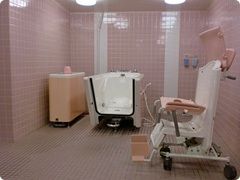 白い浴槽の一面の壁がなく、そばには椅子型のリフトがあり、浴槽部分に椅子の部分がドッキングするデザインとなっている。