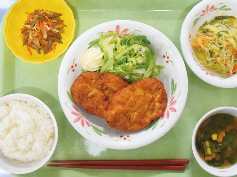 チキンとサラダ、あえ物とスープ、ごはんのメニューを写した写真