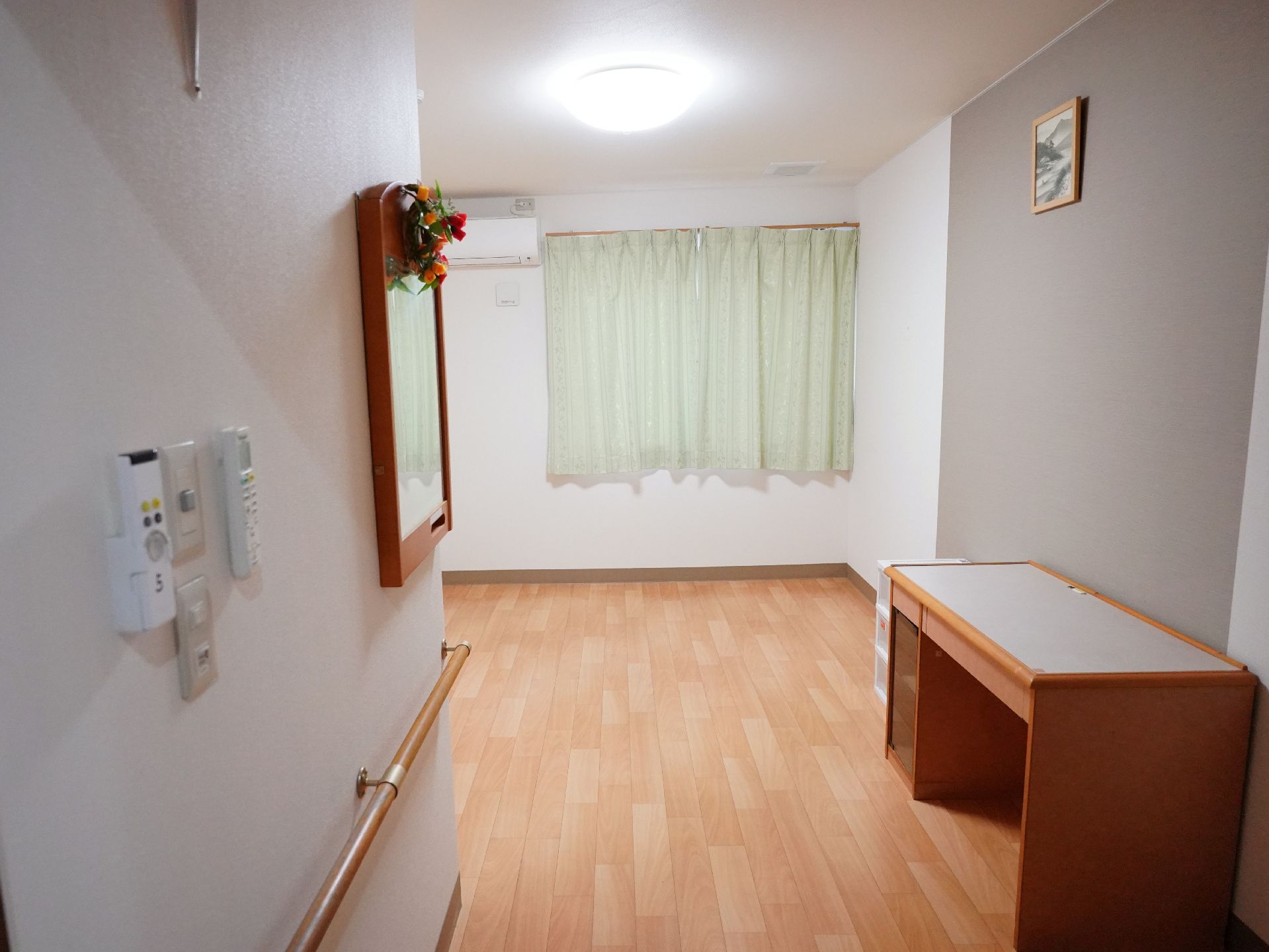窓から日差しが差し込み、介護ベッドが置かれている居室