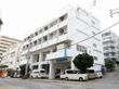 鉄骨造４階建ての建物の様子。駐車場スペースがある広めの敷地内