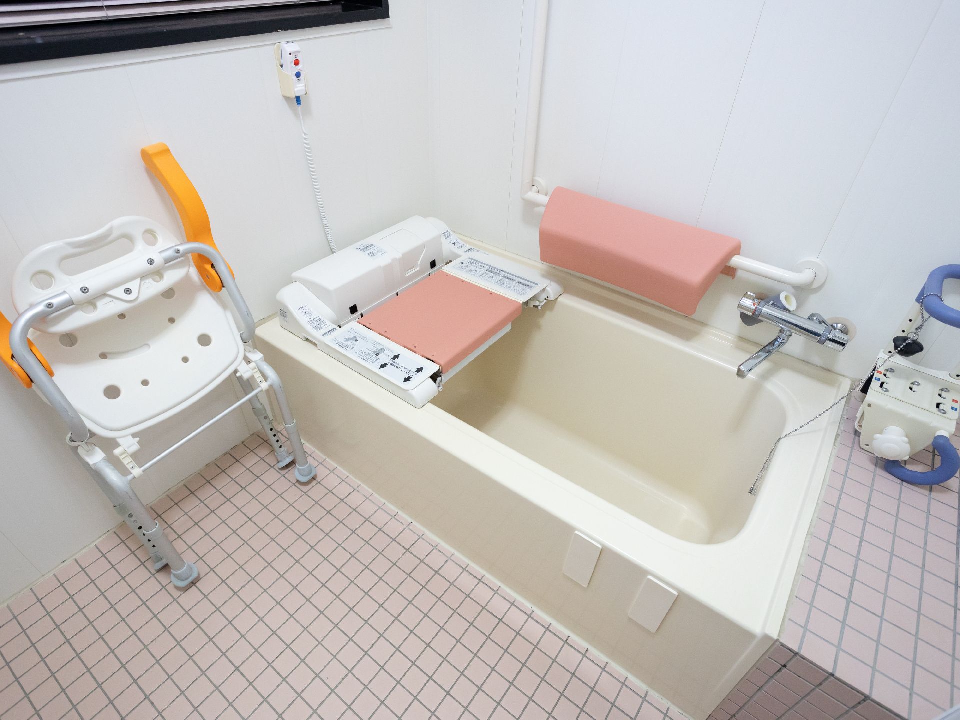 手すりが取り付けられ、落ち着いた色合いの浴室