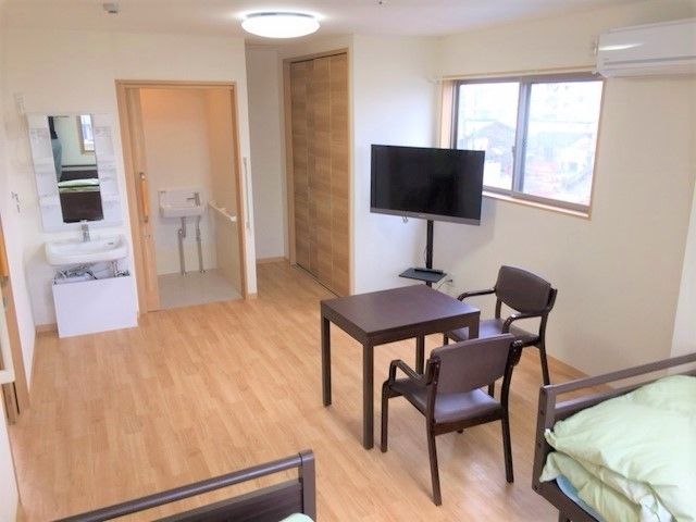 寝具付きのベッドが２台置かれたフローリングの部屋にはトイレや洗面所もあり、車いす対応の造りとなっている。