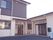 右側には平屋建ての建物があり、左側には2階建ての建物。それぞれに玄関があり、事業所名が書かれている。