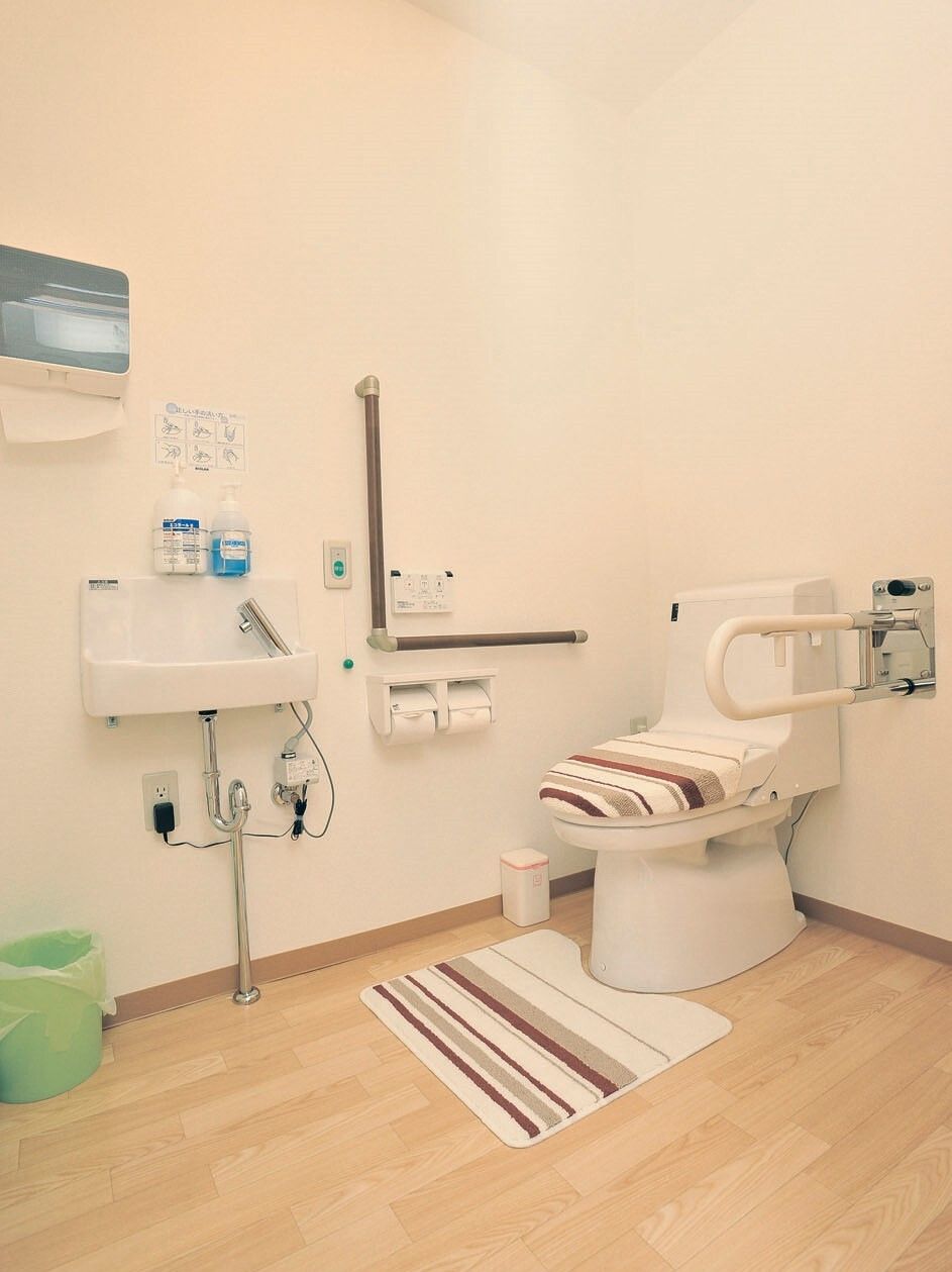 広々としたトイレには可動式の手すりとエル字型の手すりが付き、ペーパータオルが設置され、車いす対応の洗面所や呼び出しボタンもある。