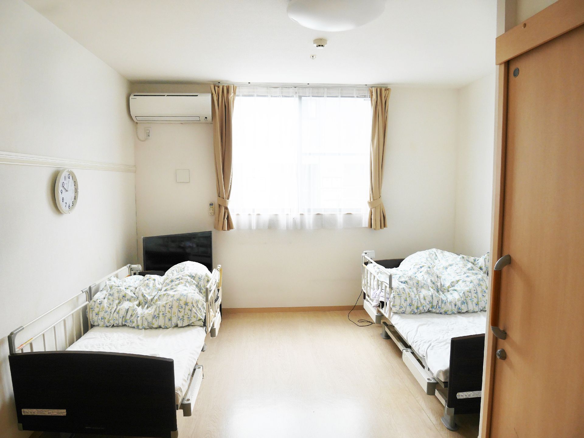 レトロな雰囲気のタンスやちゃぶ台、座椅子などが置かれた部屋。ござが敷かれ、和の雰囲気。神棚がタンスの上に置かれている。