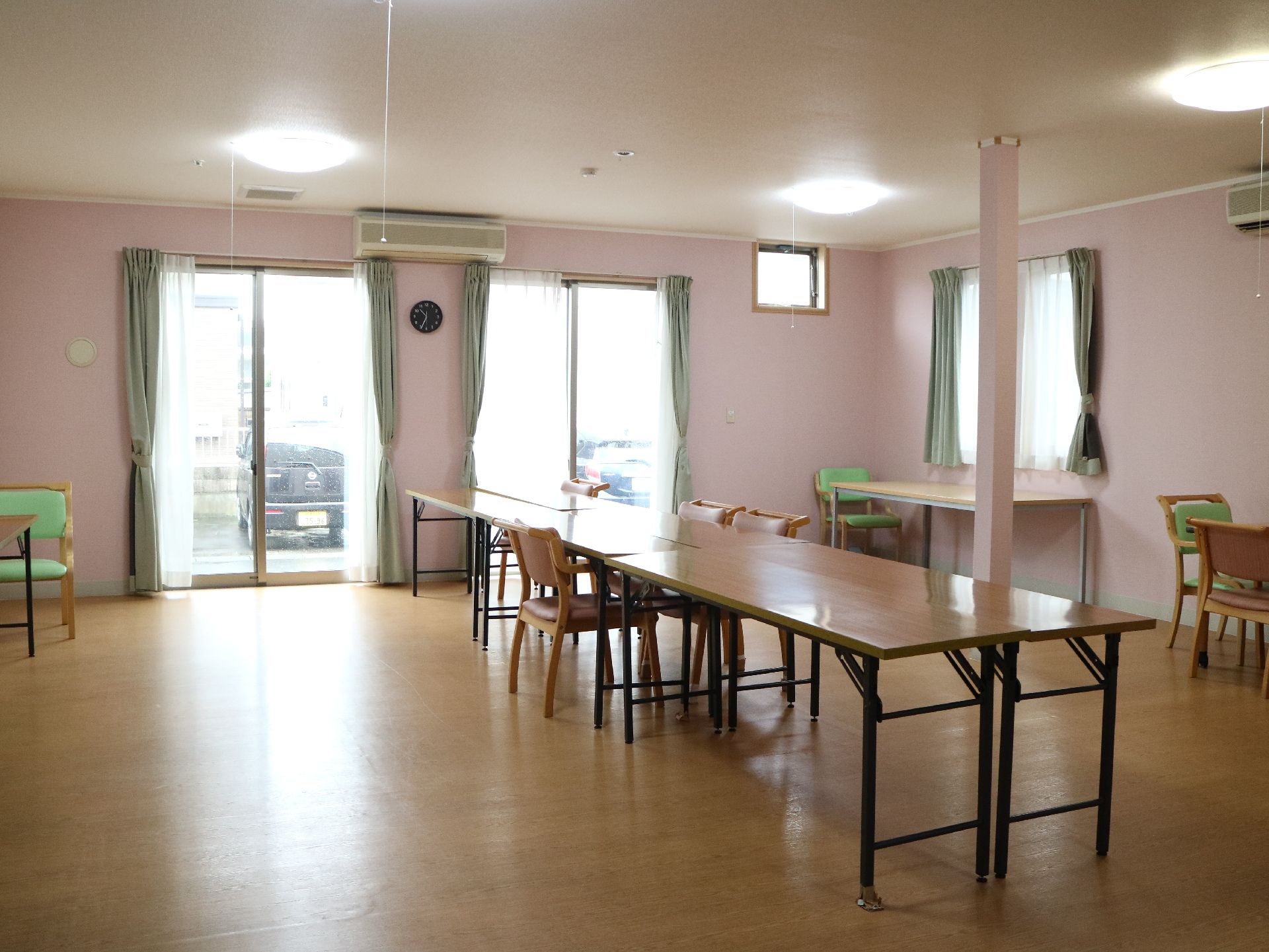 中央に大人数が一度に利用できる長机が置かれたエアコンのある部屋